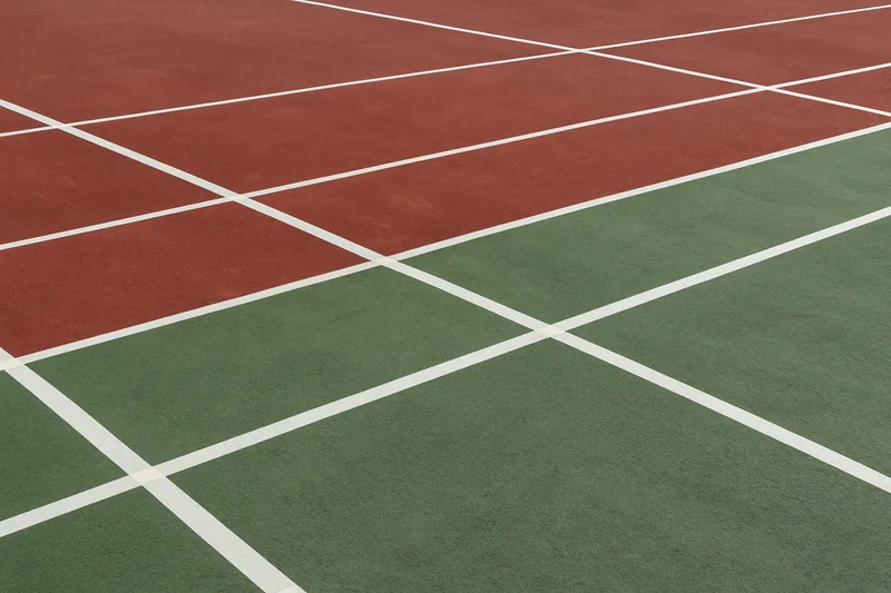 Masking tape laid in straight lines across a coloured court surface — tennis court resurfacing, Adelaide. Illustrative example.
